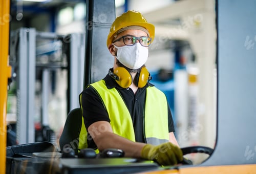 Preview: Man worker forklift driver with protective mask working in industrial factory or warehouse