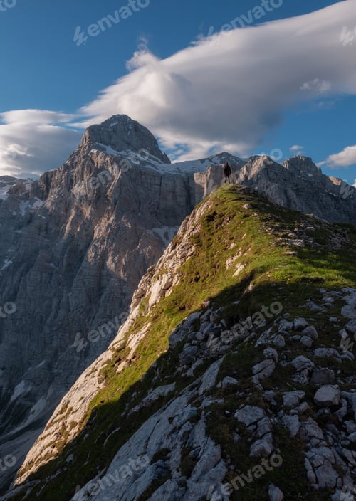 Vista previa: Hiker in the mountains standing below the top