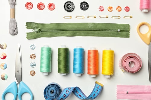 Flat lay with sewing supplies on white background