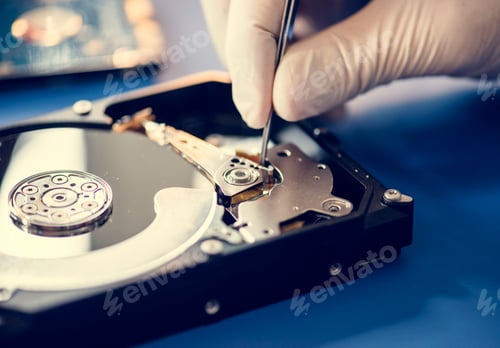 Preview: Closeup of hands with tweezers and computer hard disk