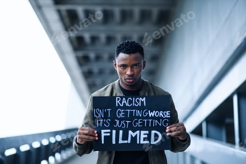 Preview: Man with written sign standing outdoors, black lives matter concept