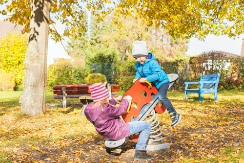 Preview: Boy and girl swing on a swing. Children's friendship, walks and outdoor games with children. Autumn