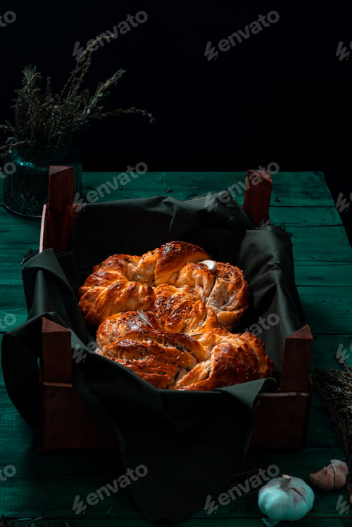 Preview: Freshly made Italian bread on greenwooden board with herbs and garlic, Mediterranean Food background