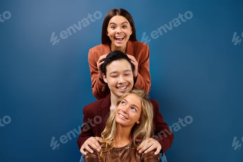 Preview: merry diverse adolescents in elegant outfits smiling at camera while posing together, friendship day
