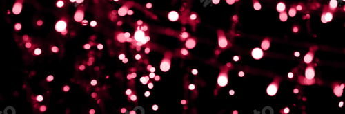 Preview: Blurry garland lights on a dark background. color of the year 2023 viva magenta