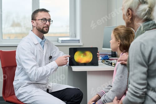 Preview: Male Doctor Showing Retinal Scan to Senior Woman and Young Girl