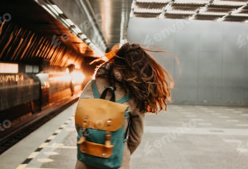 Preview: Young woman curly red head girl traveller with backpack and map in subway station in front of train