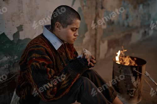 Preview: Poor homeless woman eating sandwich while warming at bonfire