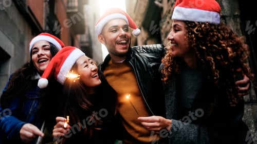 Preview: Happy diverse friends celebrate Christmas party with sparkler fireworks outdoors