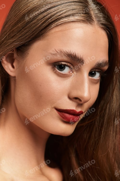 Preview: Beautiful young woman with long hair and striking features posing against a vibrant background
