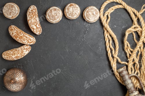 Preview: Top view of delicious cookies rope with decoration accessory on dark background