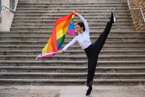 Preview: Female dancer holding rainbow flag showing flexibility urban stairs