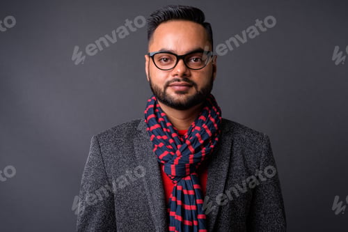 Preview: Young bearded Indian businessman against gray background