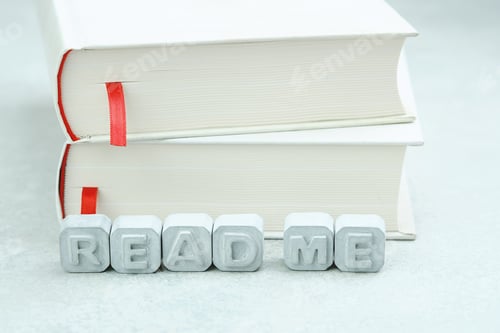 Preview: Text Read Me made of gray concrete letters on a white book. Motivation for reading.