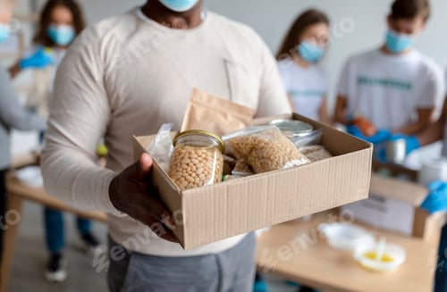 Preview: Senior black man holding box with donations food, cans and packages with grains and pasta, cropped