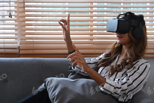 Preview: Pretty young woman watching video or play video game on virtual reality headset.