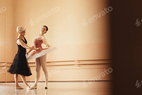 Preview: Smiling ballerina rehearsing with her mature instructor at ballet studio.