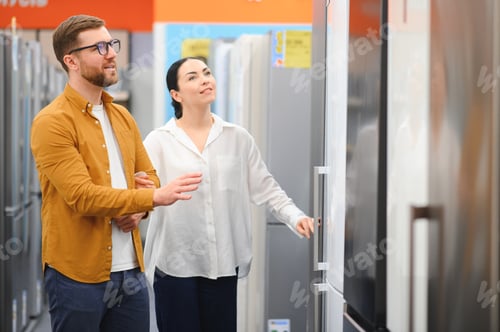 Preview: couple, satisfied customers choosing fridge in appliances store