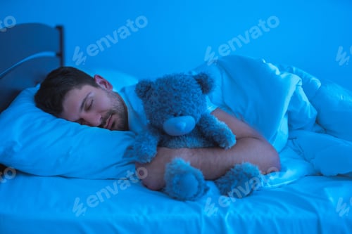 Preview: The man sleeping with a soft toy. evening night time