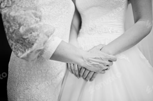 Preview: Mom hand hold her daughter bride on wedding day. Black and white photo