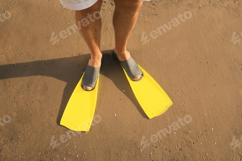 Preview: Man in flippers on wet sand, closeup