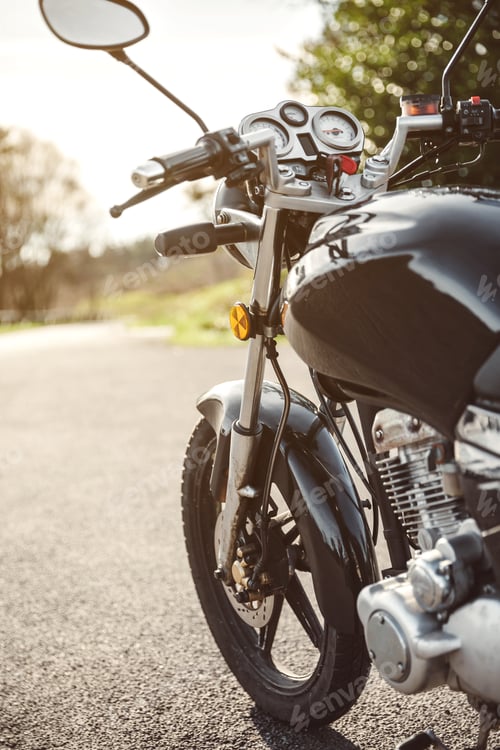 Preview: Black motorcycle on road over nature background