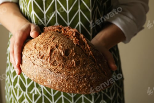 Preview: Woman in apron hold fresh baked bread