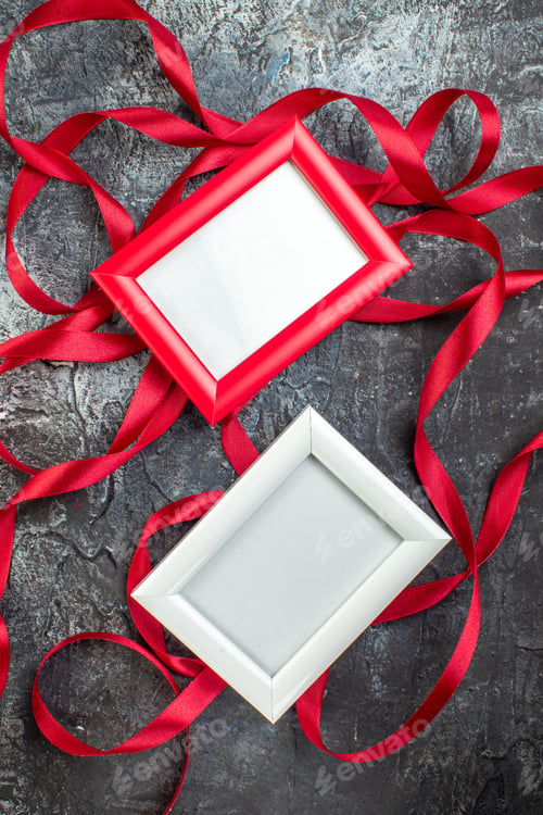 Preview: Vertical view of red and white picture frames ribbon on icy dark background