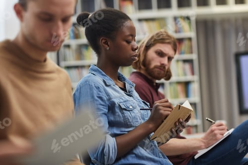 Preview: African woman writing at lecture