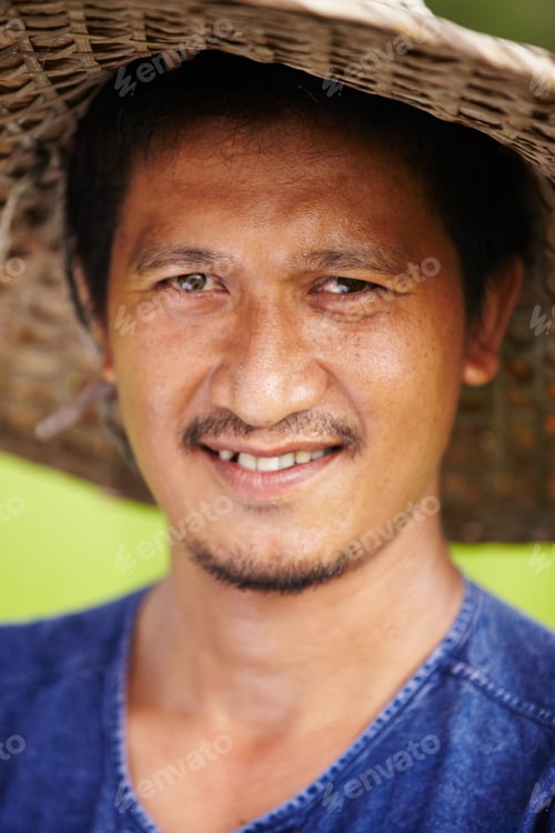 Preview: Closeup portrait of a Thai rice paddy worker wearing a traditional hat