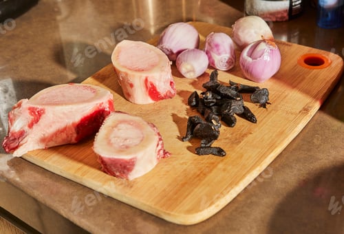 Preview: Ossobuco with spindle Beef and black garlic on plate ready for cooking. French gourmet cuisine