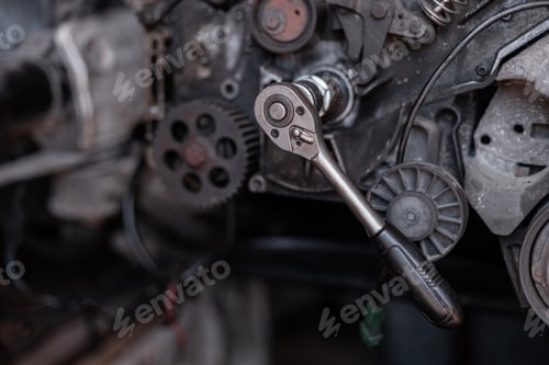 Preview: auto mechanic turns the key on the engine in the garage. Repair and disassembly of the V8 engine