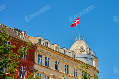 Preview: Danish flag on roof of building against blue sky