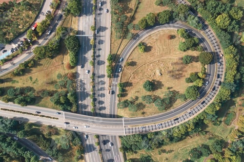 Preview: Cars drive along loop shaped road junction aerial view.