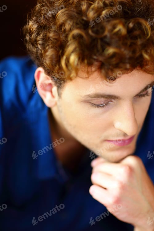Preview: Closeup portrait of a young pensive man with curly hair
