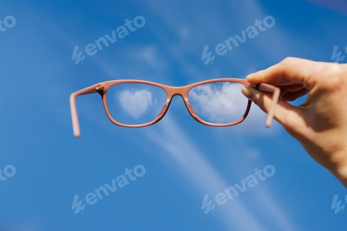 Preview: Eyeglasses show clear sky with clouds. Concept of clarity, optimism, and visual focus.