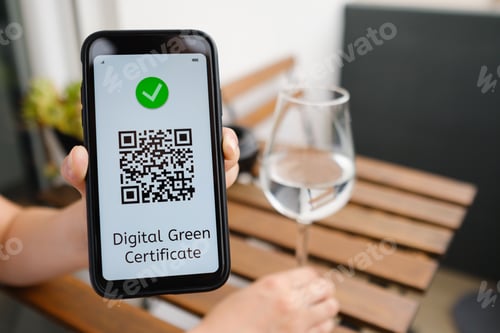 Preview: Woman demonstrates Digital green certificate with QR code in mobile phone sitting in the cafe