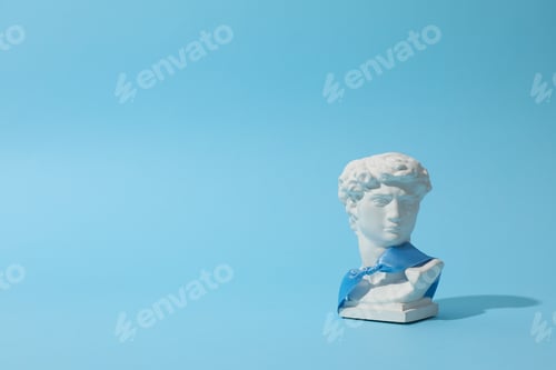 Preview: Ancient head with blue ribbon on blue background