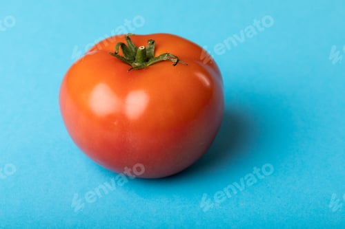 Preview: Close-up of fresh red tomato by copy space over blue background