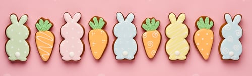 Preview: Easter greeting card with colorful rabbits, eggs, chickens and carrots gingerbread cookies on pink b