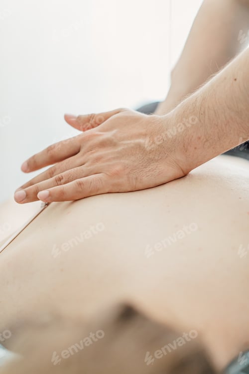 Preview: Male masseur with strong hands professionally massaging scapulas and shoulders. Beautiful naked