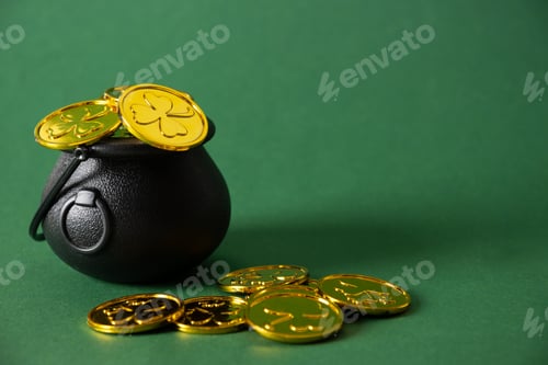 Preview: St. Patrick's day black pot with golden coins on green background.