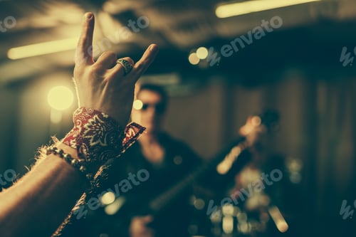 Preview: selective focus of man showing rock sign near musician