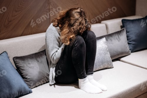 Preview: Teenager girl crying on couch. Puberty and depression