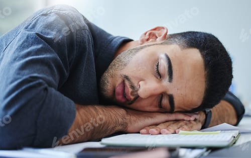 Preview: Shot of a young businessman feeling exhausted and sleeping on his desk in his office