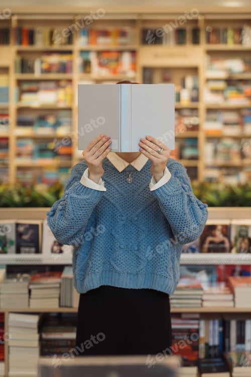 Preview: Person reading a book hiding face in library