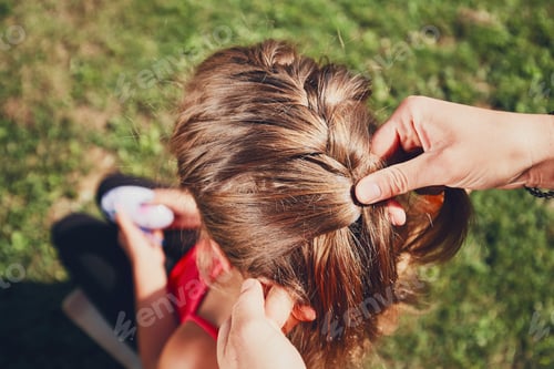 Preview: Child Getting Her Hair Braided in the Sun