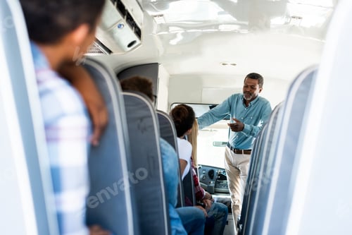Preview: rear view of teen students sitting at school bus and listening to mature african american teacher