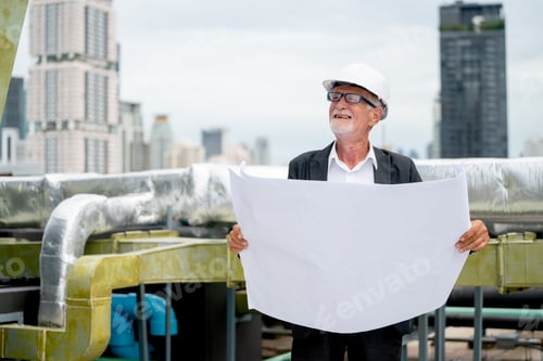 Preview: Senior engineer or technician worker hold building plan or drawing and look around in site