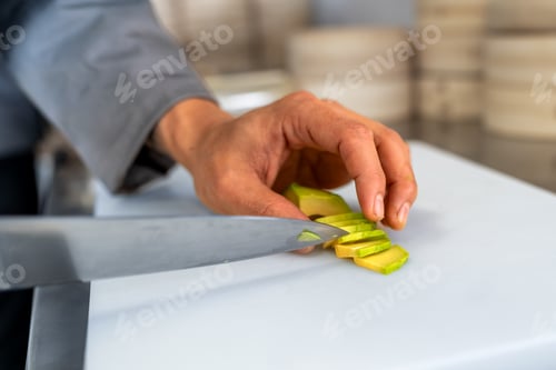 Preview: Chef slicing avocado on cutting board in kitchen for meal preparation